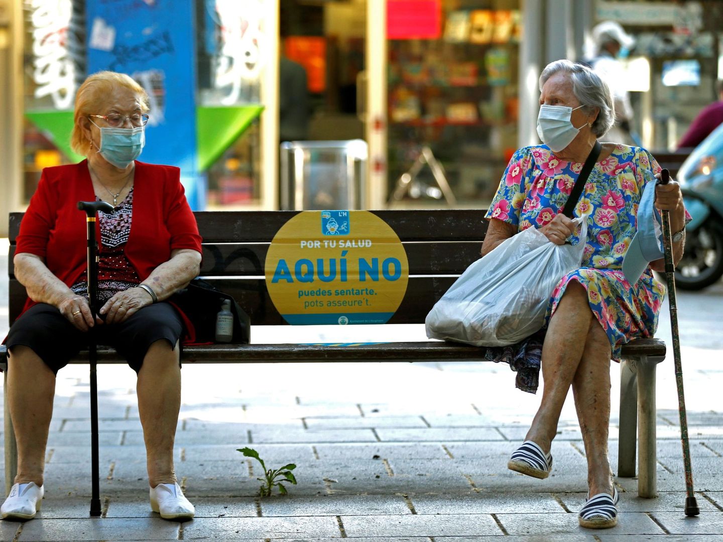 Dos mujeres conversan en un banco de L'Hospitalet (Barcelona). (EFE)