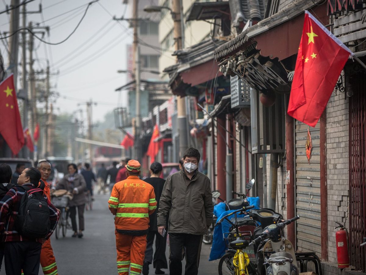 Foto: Un hombre camina con mascarilla por una calle de Pekín. (EFE/Roman Pilipey)