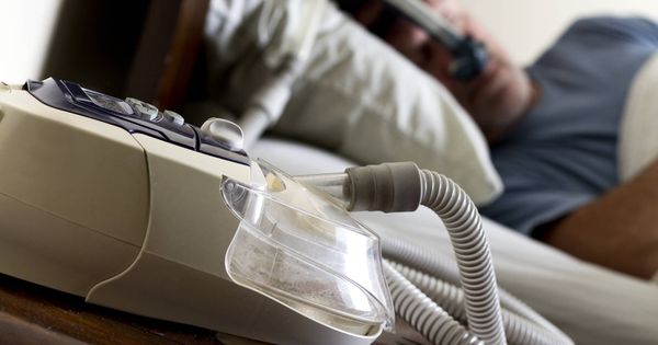 Foto: Un hombre durmiendo con una máquina CPAP. (iStock)