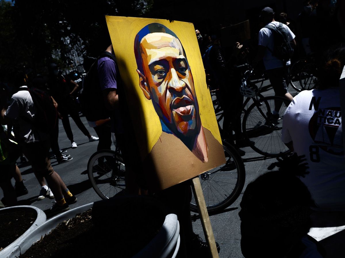 Foto: Una persona sostiene una pancarta con un retrato de George Floyd durante las protestas contra el racismo en Nueva York. (Reuters)