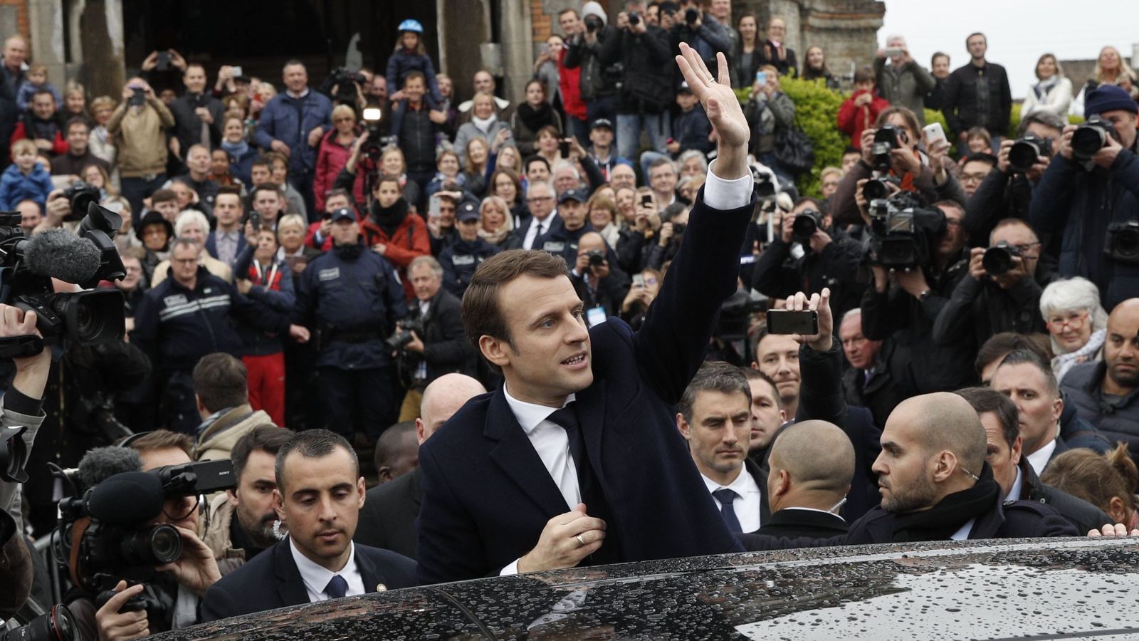 Foto: El candidato Emmanuel Macron (C) saluda a los ciudadanos tras ejercer su derecho al voto. (EFE)