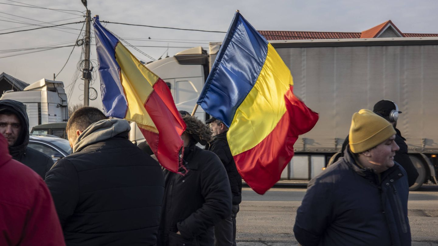 Varios manifestantes con tractores y camiones ondean banderas de Rumanía en el andén de la autovía de circunvalación de Bucarest, DN2, a la altura del municipio de Afumati, a unos 20 kilómetros de la capital, el pasado 13 de enero. (L. G.)