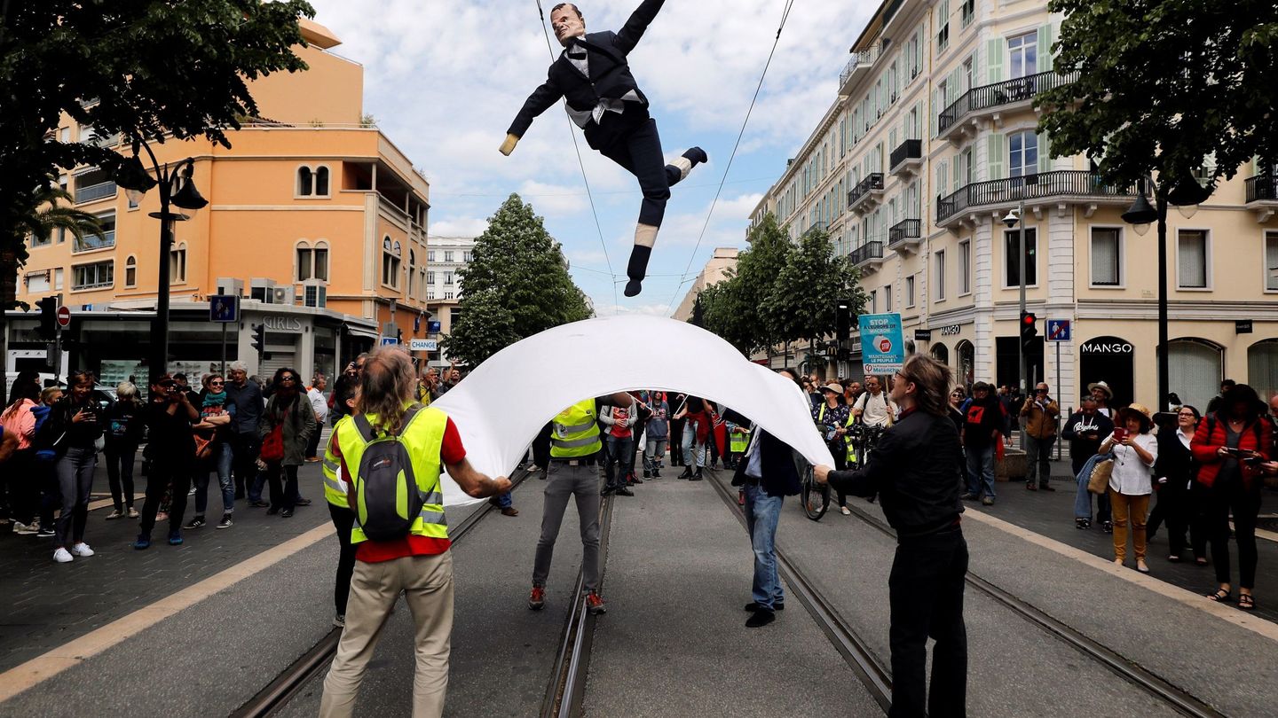 Varias personas lanzan una efigie del presidente francés, Emmanuel Macron, durante una manifestación. (EFE)