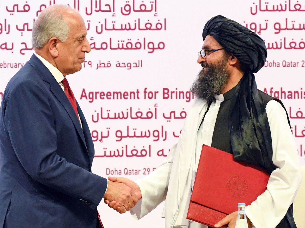 Foto: El representante especial de EEUU para la paz, Zalmay Khalilzad, y, el líder talibán mulá Abdul Ghani Baradar, firman el acuerdo en Qatar. (EFE)