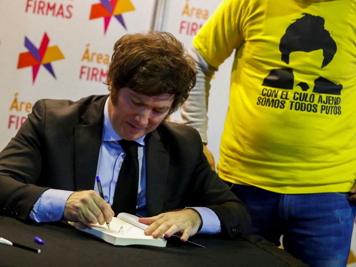 Foto: El presidente argentino, Javier Milei, firmando ejemplares de 'El camino del libertario' en 2022. (Reuters)