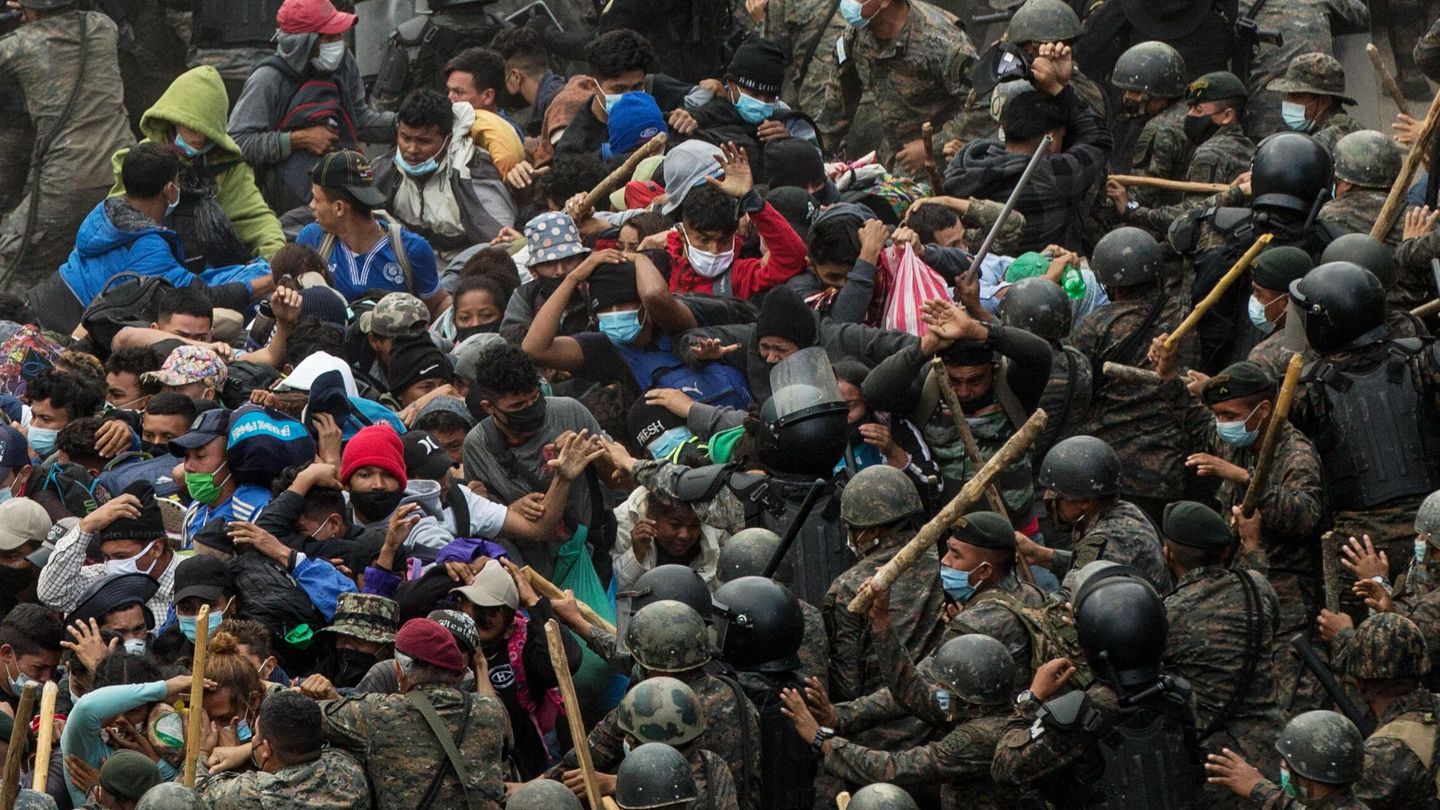 Soldados y policías guatemaltecos golpean a un grupo de migrantes hondureños que caminan por una carretera, en Chiquimula (Guatemala). (EFE)