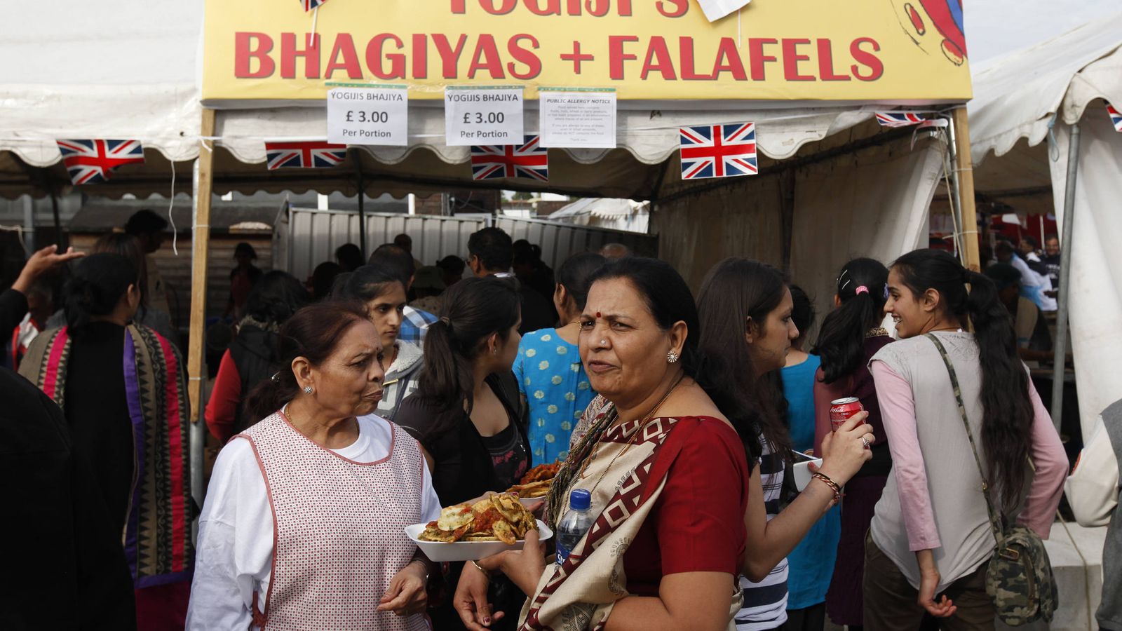 Foto: Varias personas hacen cola en un puesto de comida india durante una celebración en la escuela Swaminarayan en Londres, en junio de 2012. (Reuters)