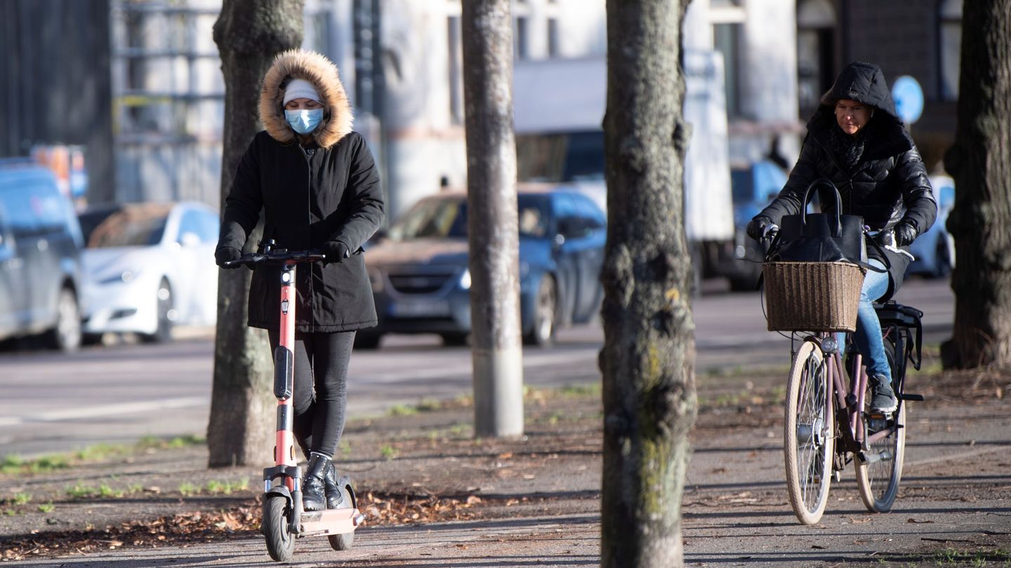 Mujer con patinete y mascarilla en Estocolmo. (Reuters) 