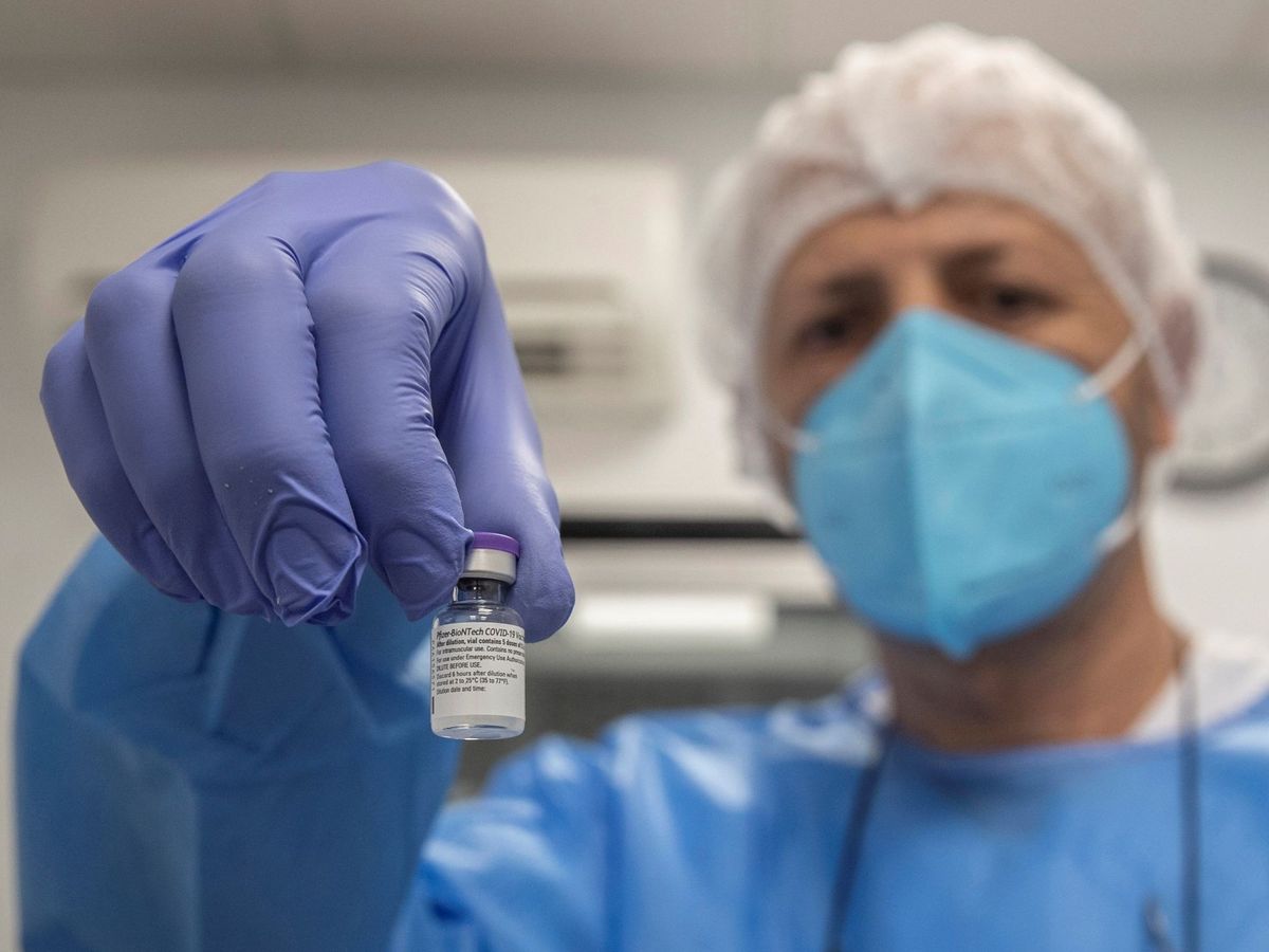 Foto: Un enfermero de la armada española muestra un vial de la vacuna contra el coronavirus. (EFE) 