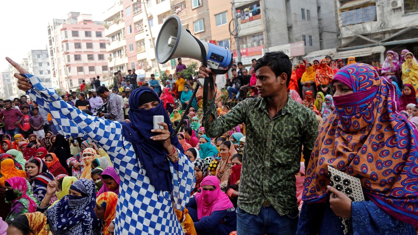Empleados bangladesíes del textil gritan consignas durante una protesta para demandar un mayor salario mínimo en Dacca, Bangladesh. (EFE)