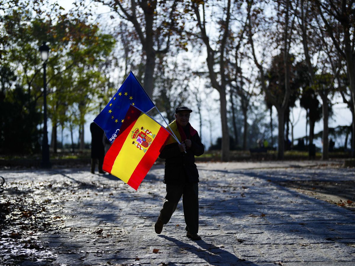 Foto: Un hombre porta una bandera española y otra de la Unión Europea. (EFE / Fernando Alvarado)