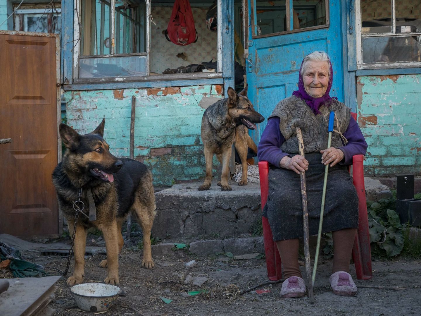 Una mujer posa junto a sus dos perros frente a su casa, en Kiev (Ucrania). (EFE /  Miguel Gutiérrez )