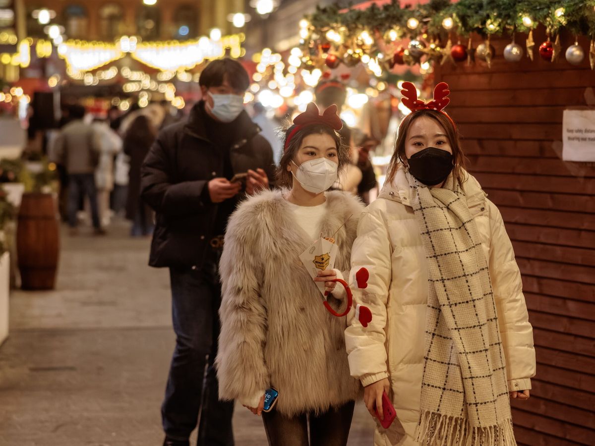 Foto: Dos mujeres pasean con mascarillas en Shanghái. (EFE/Alex Pavlevski)