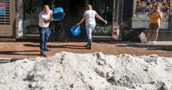 Foto: Comerciantes de Arganda del Rey sacan cubos de granizo de una tienda. (D.B.)