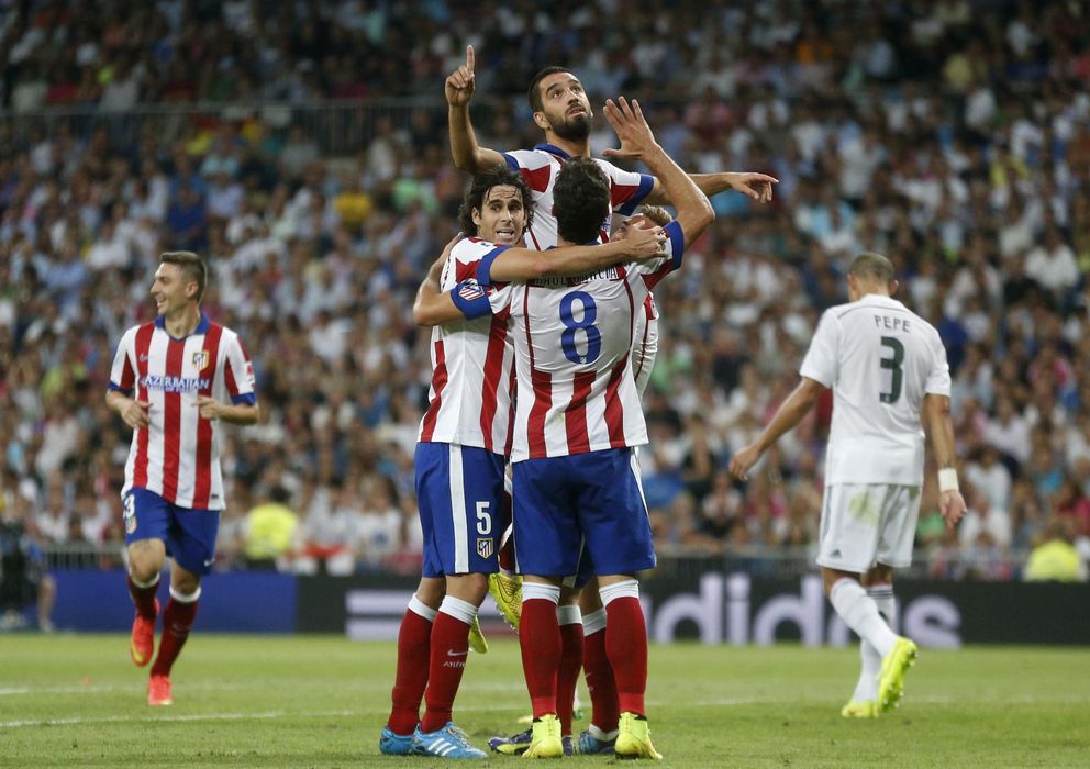 Foto: Arda Turdan rodeado por su compañeros celebra el segundo gol del Atlético en el Bernabéu. 