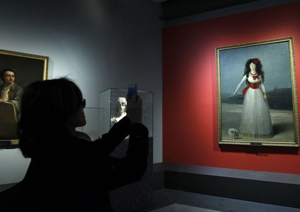 Foto: Una visitante toma una fotografía con su móvil del cuadro 'La duquesa de Alba de blanco', de Francisco de Goya, de la familia Alba. (EFE)