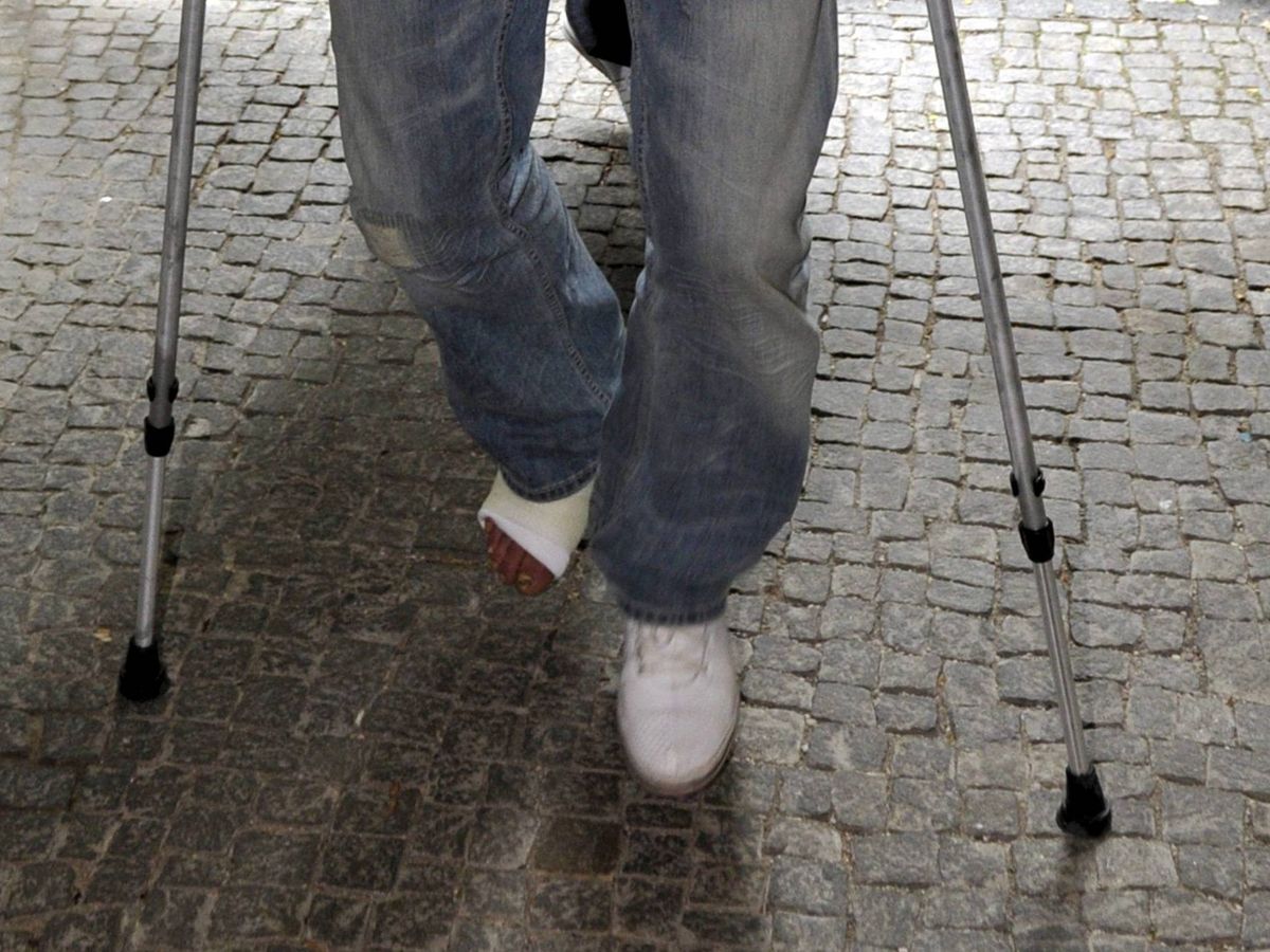 Foto: Un hombre camina con muletas y una pierna escayolada. (EFE/Marc Mueller)