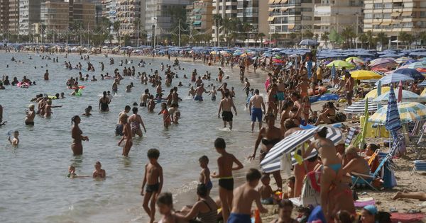 Foto: Miles de turistas disfrutan del sol y el agua en la playa de Levante de Benidorm. (EFE)