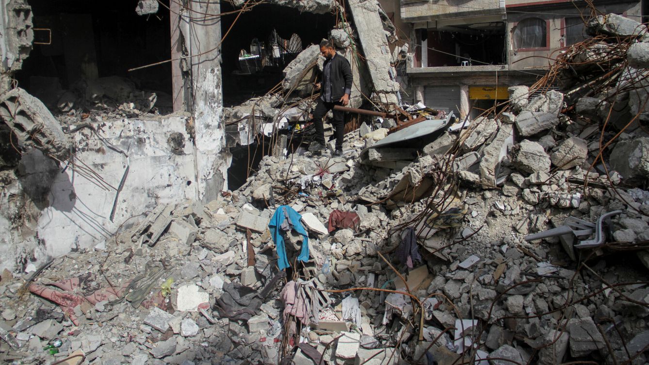 Foto: Un ciudadano palestino busca en los escombros de su casa pertenencias tras un bombardeo israelí. (Reuters)