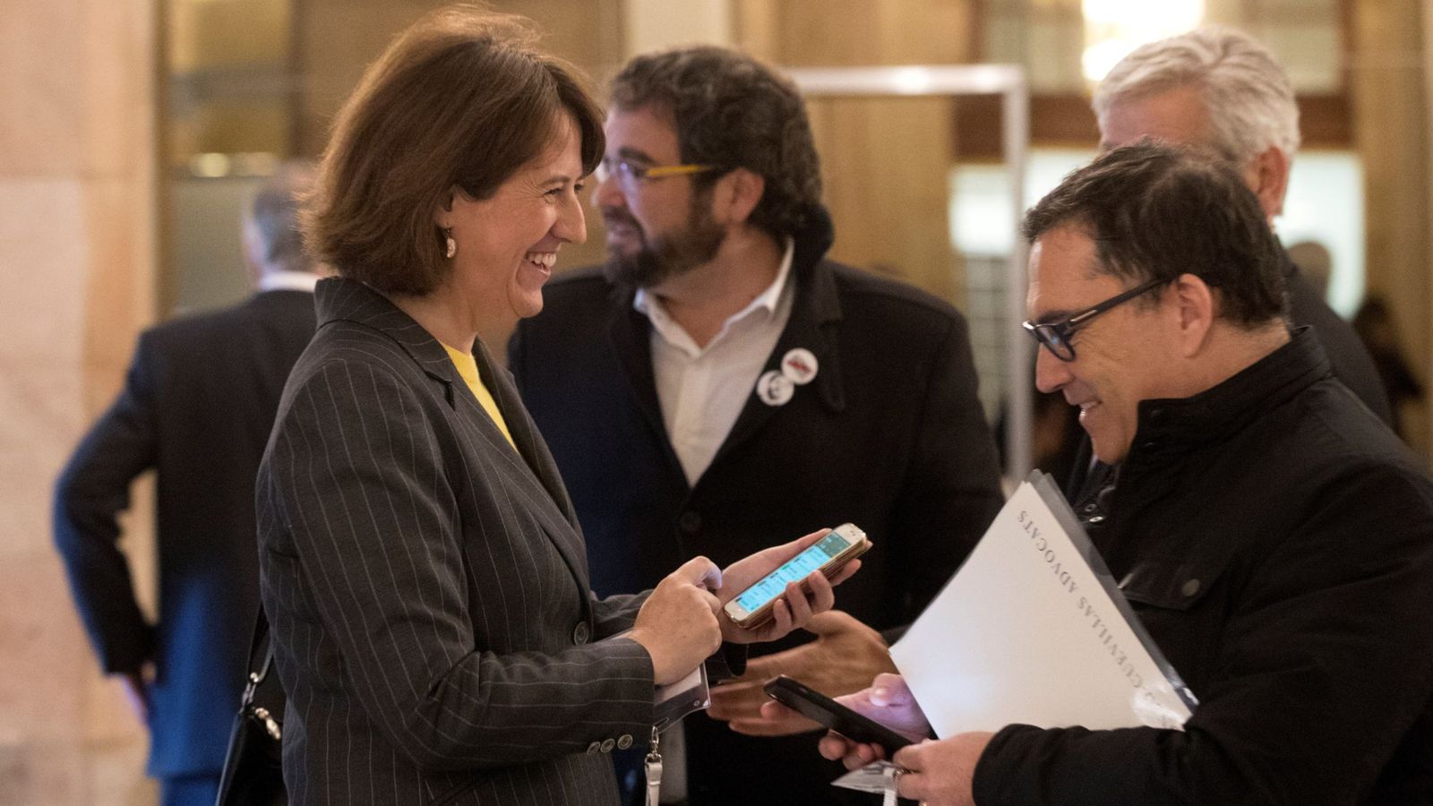 Foto: La presidenta de la ANC, Elisenda Paluzie (i), departe con el abogado de Carles Puigdemont, Jaume Alonso Cuevillas (d), en los pasillos del Parlament. (EFE)