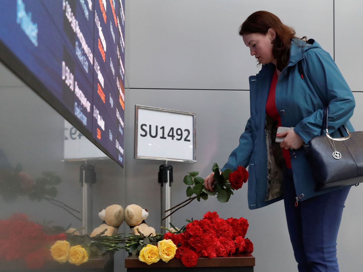Una mujer deja flores en el aeropuerto de Sheremetyevo de Moscú en memoria de los fallecidos. (Reuters)