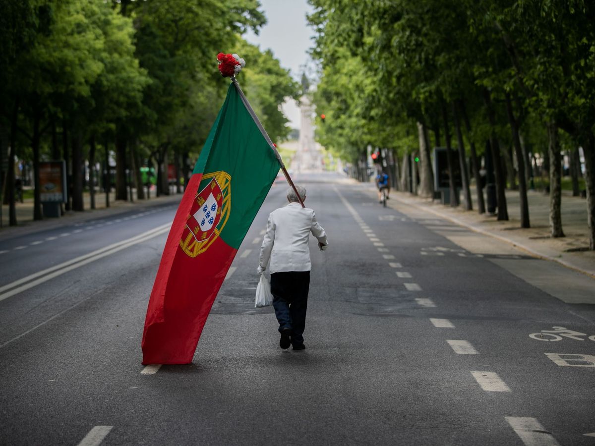 Foto: Un hombre con la bandera de Portugal en la Avenida da Liberdade de Lisboa. (EFE/EPA/Jose Sena Goulao)