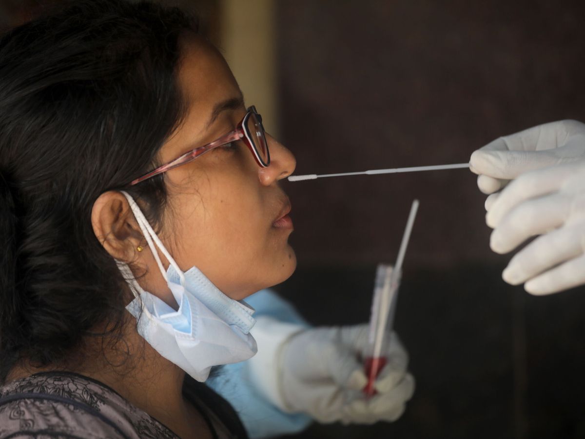 Foto: Una mujer se somete a un test covid. (EFE/ Piyal Adhikary)