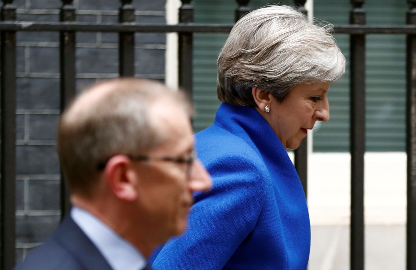 Theresa May sale de su domicilio en Downing Street junto a su marido con la vista baja. (Reuters)