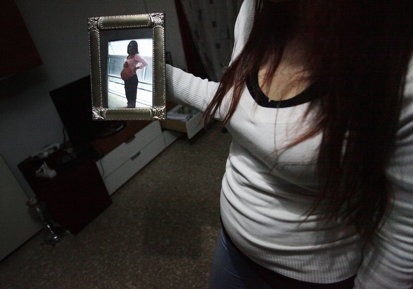 Nuria, embarazada de dos meses y medio, sosteniendo una foto de su primer embarazo. (Foto: Enrique Villarino)