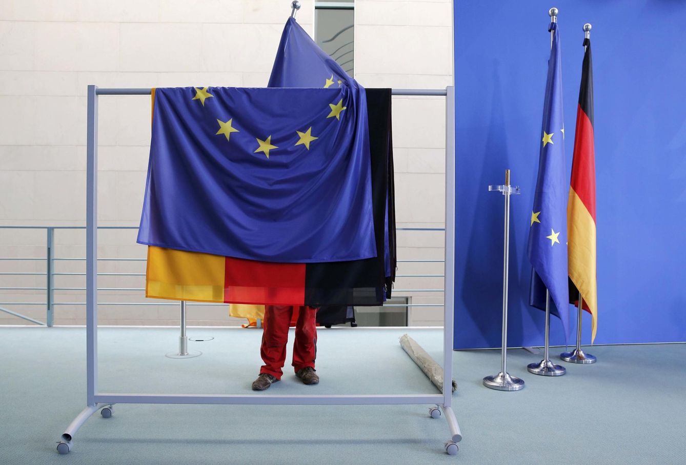 Una empleada prepara banderas de la UE y alemanas antes de una rueda de prensa en Berlín. (Reuters)