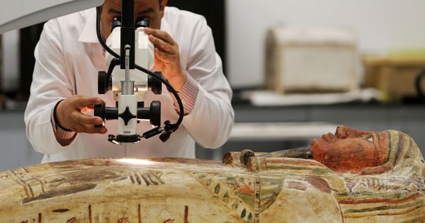 Foto: El arqueólogo Medhat Abdallah trabaja con un sarcófago de madera en El Cairo. (Reuters)