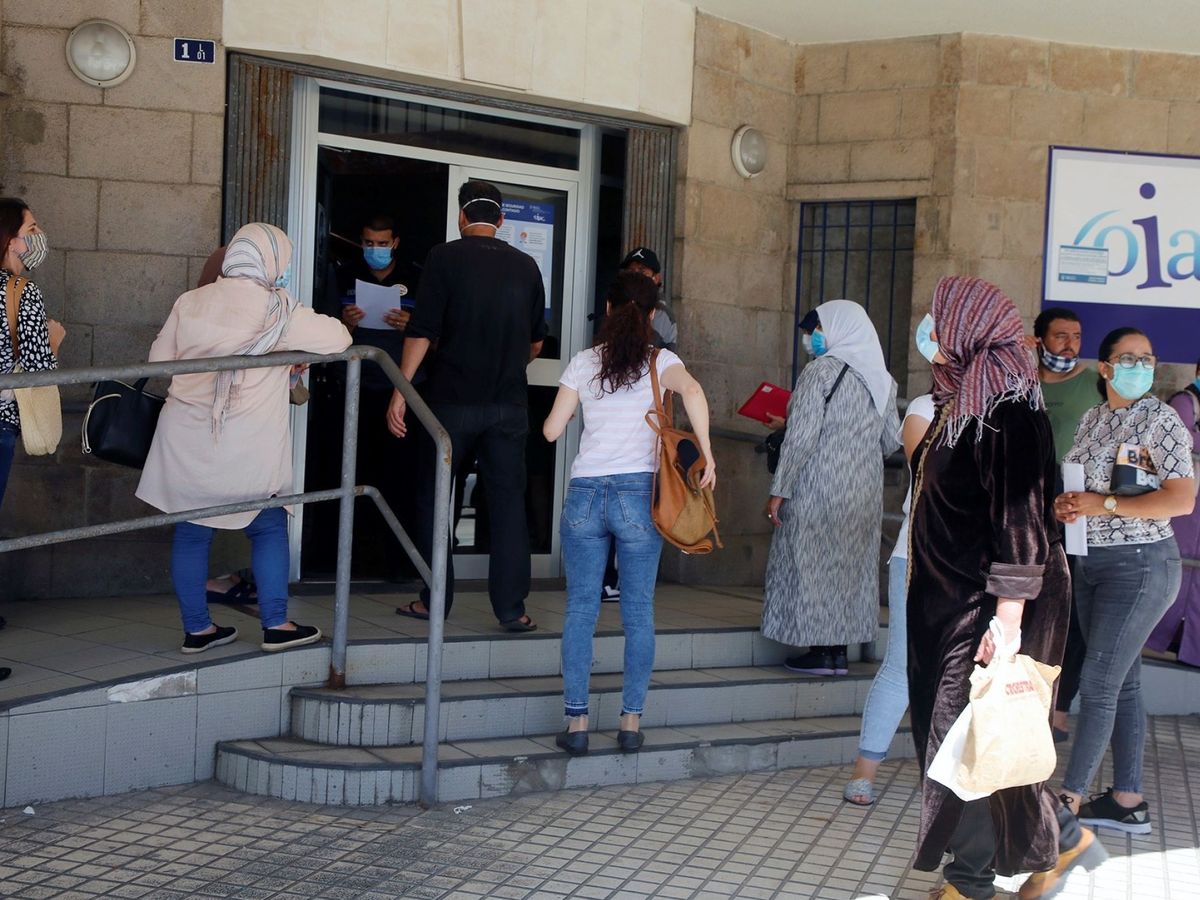 Foto: Varias personas esperan su turno para solicitar los documentos con los que pedir el ingreso mínimo vital. (EFE)