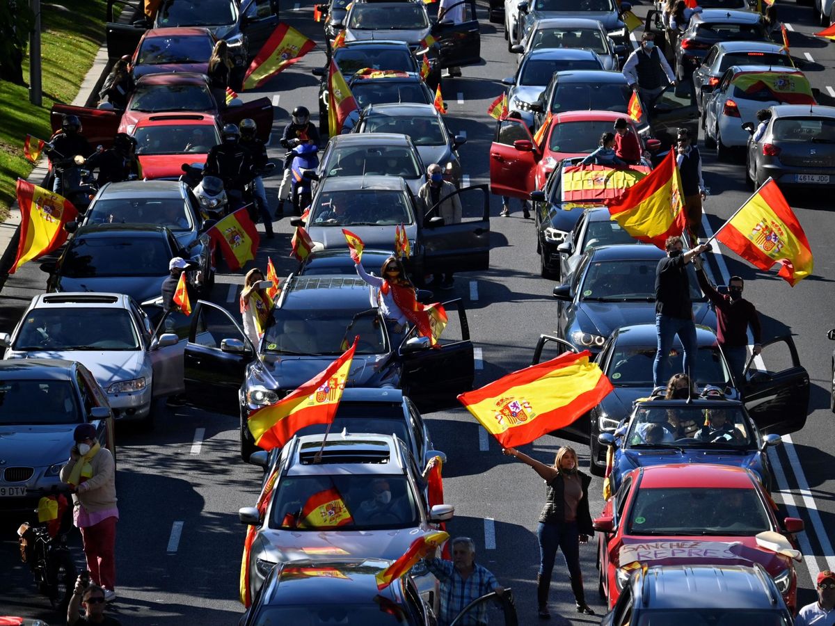 Foto: Varias personas en sus coches con banderas de España con motivo de la Fiesta Nacional. (EFE)