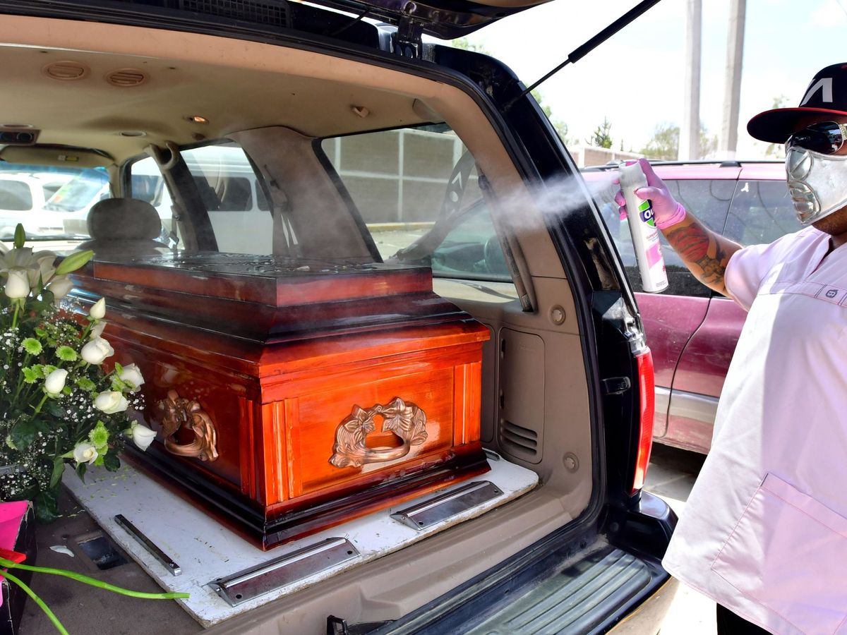 Foto: Un empleado funerario mientras desinfecta un féretro en México. (EFE)