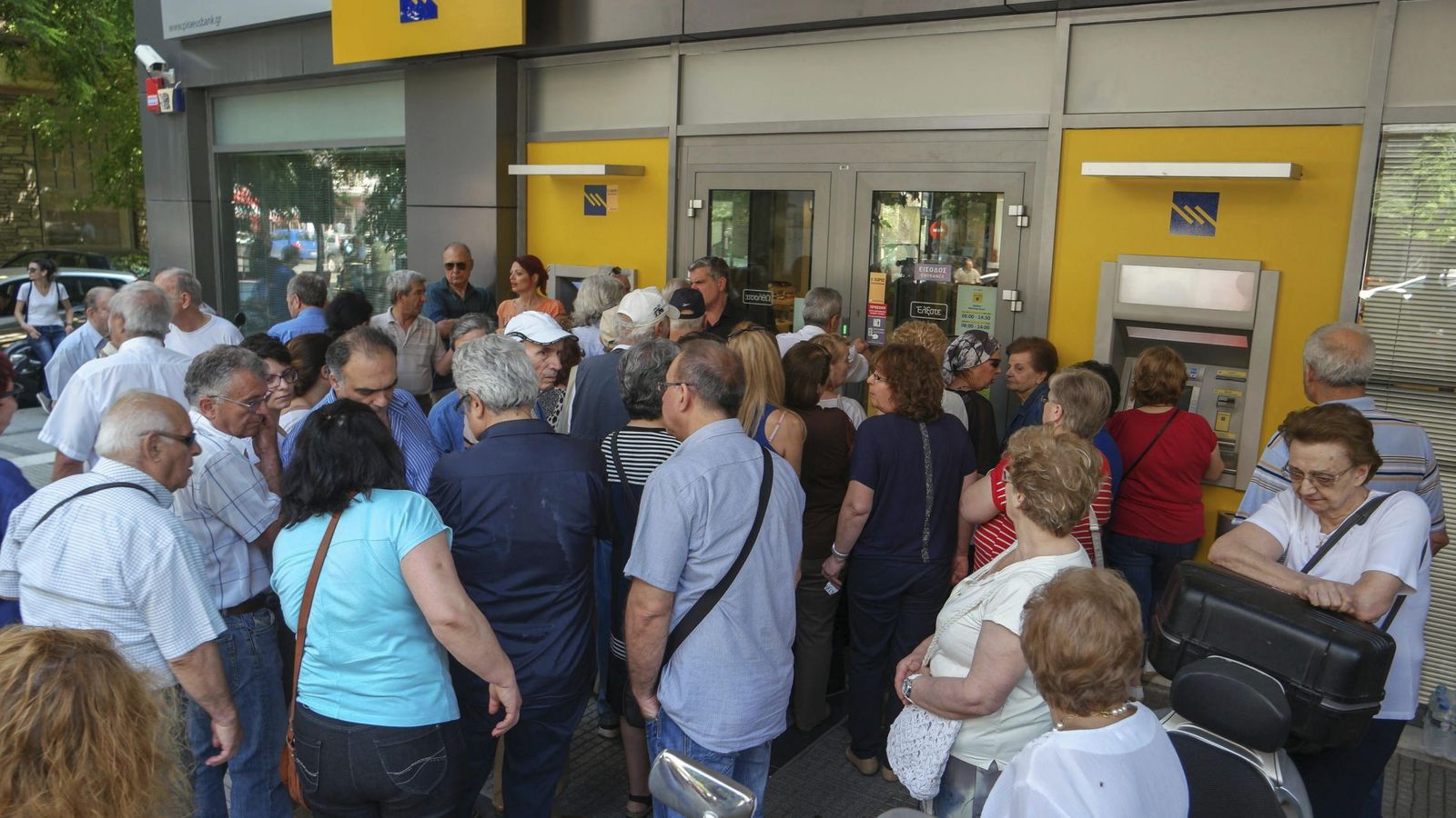 Foto: Cola para retirar dinero a la entrada de una sucursal bancaria en Salónica. (EFE)