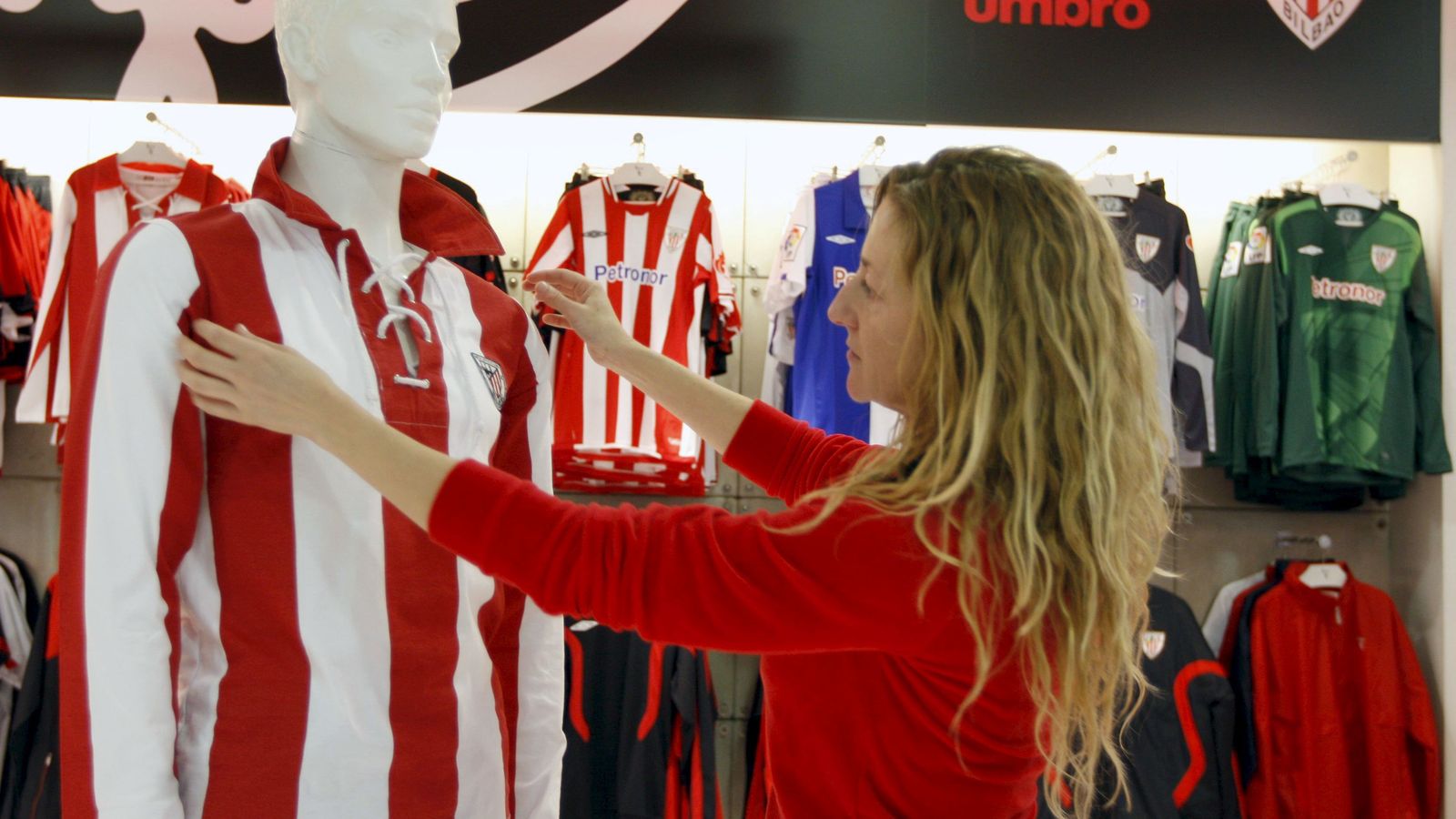 Foto: Una dependienta ajusta a un maniquí una réplica de una camiseta del Athletic. (EFE)