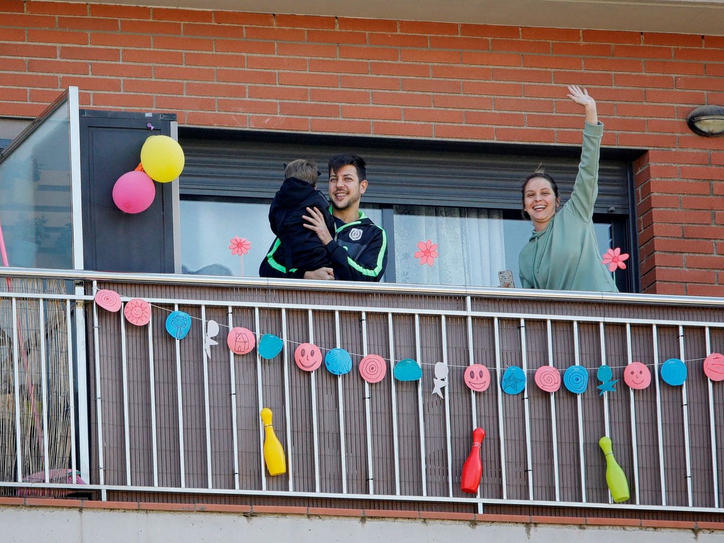 Una familia en un balcón de Barcelona.  (EFE)