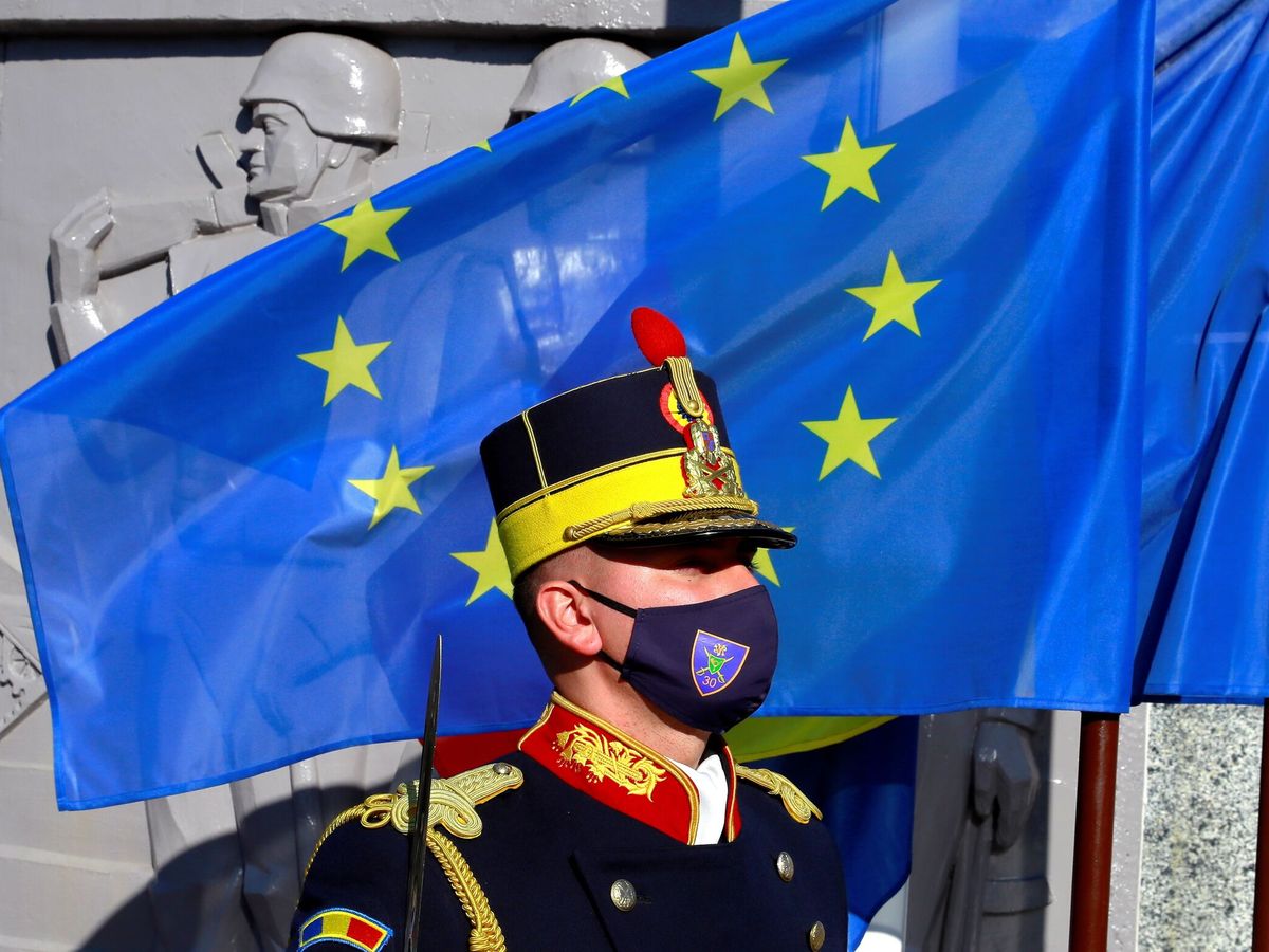 Foto: Un soldado rumano frente a la bandera de la UE. (EFE/Robert Ghement)