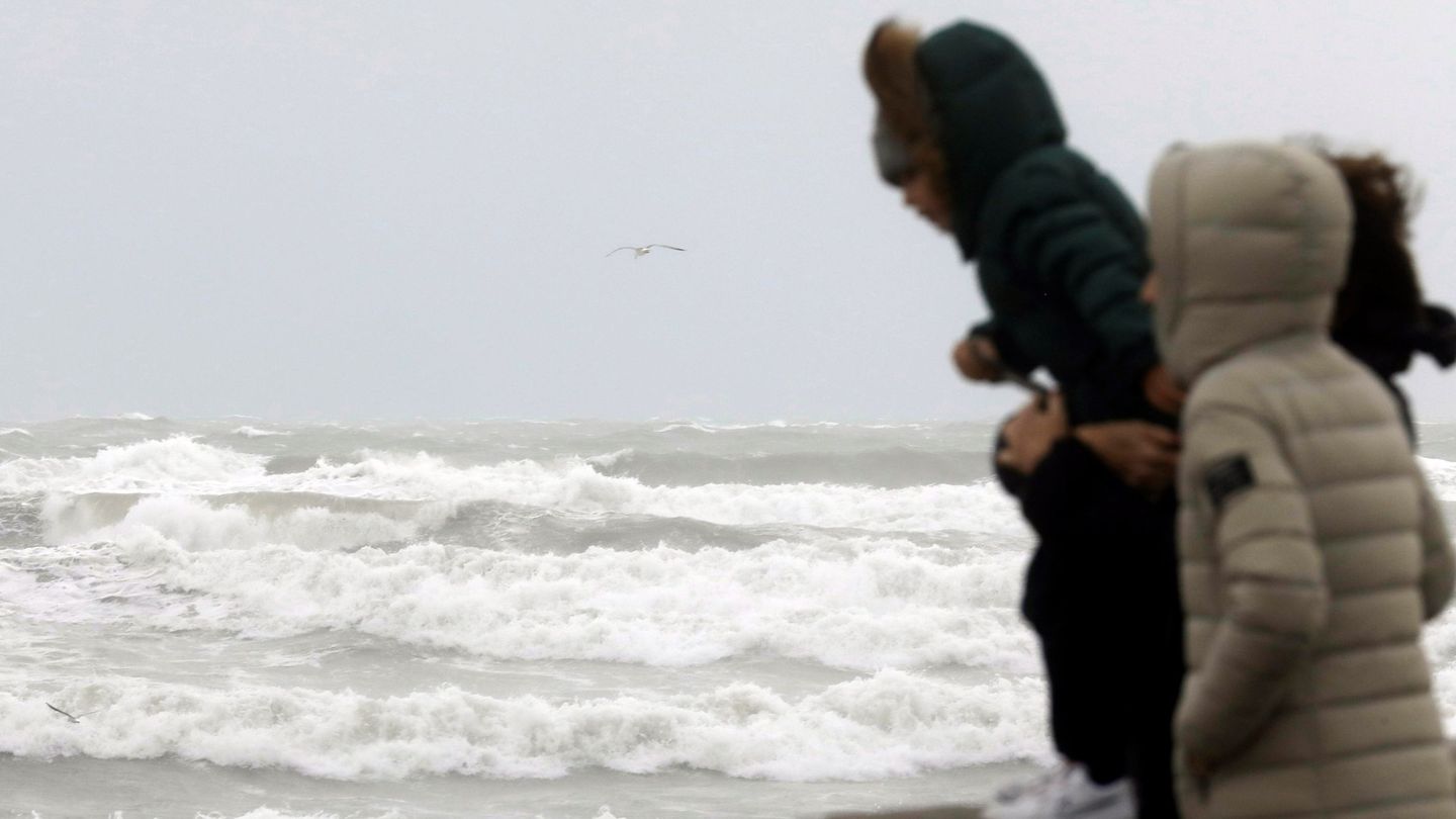 Tres personas observan el temporal marítimo en la playa de la Malvarrosa de Valencia. (EFE)