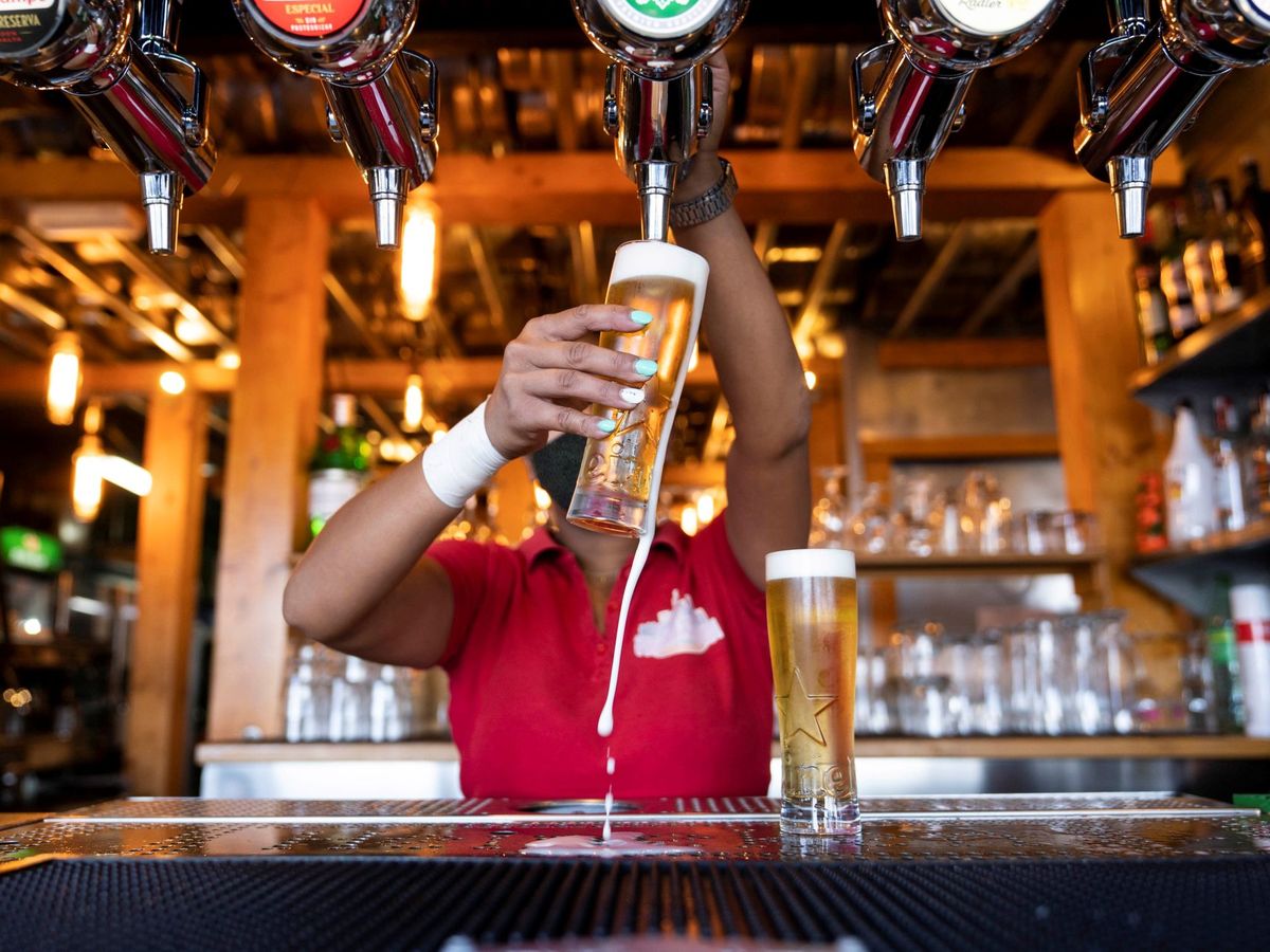 Foto: Una camarera sirve unas cervezas en un bar de Santa Cruz de Tenerife. (EFE)