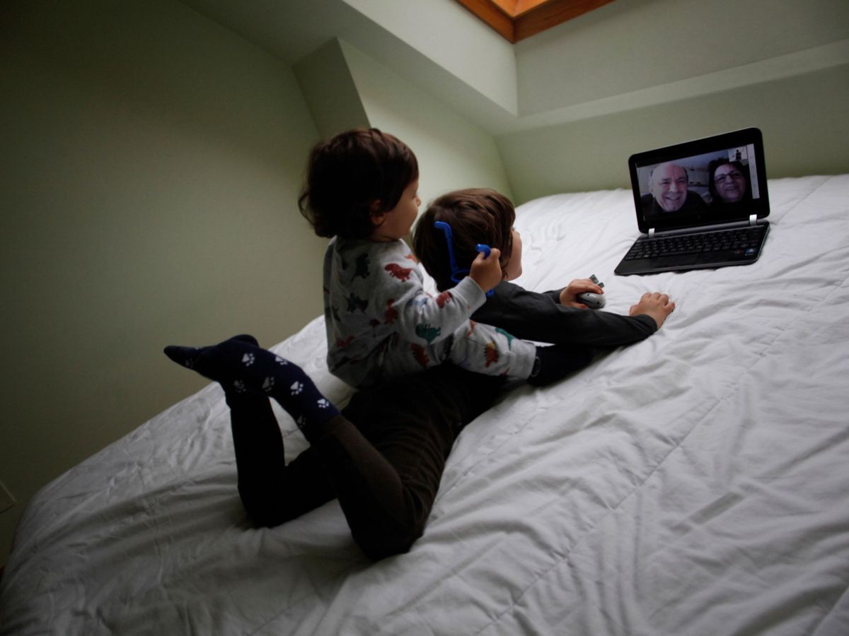 Foto: Dos niños conversan con sus abuelos mediante una videollamada. (EFE)