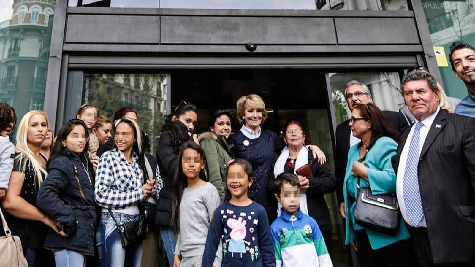 Foto: Un grupo de gitanos en la puerta de la sede del PP en Génova junto a Esperanza Aguirre (Foto: PP)