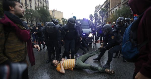 Foto: Agentes antidisturbios de la Policía Nacional forman un cordón de seguridad en los alrededores del colegio Ramón Llull de Barcelona. (EFE)