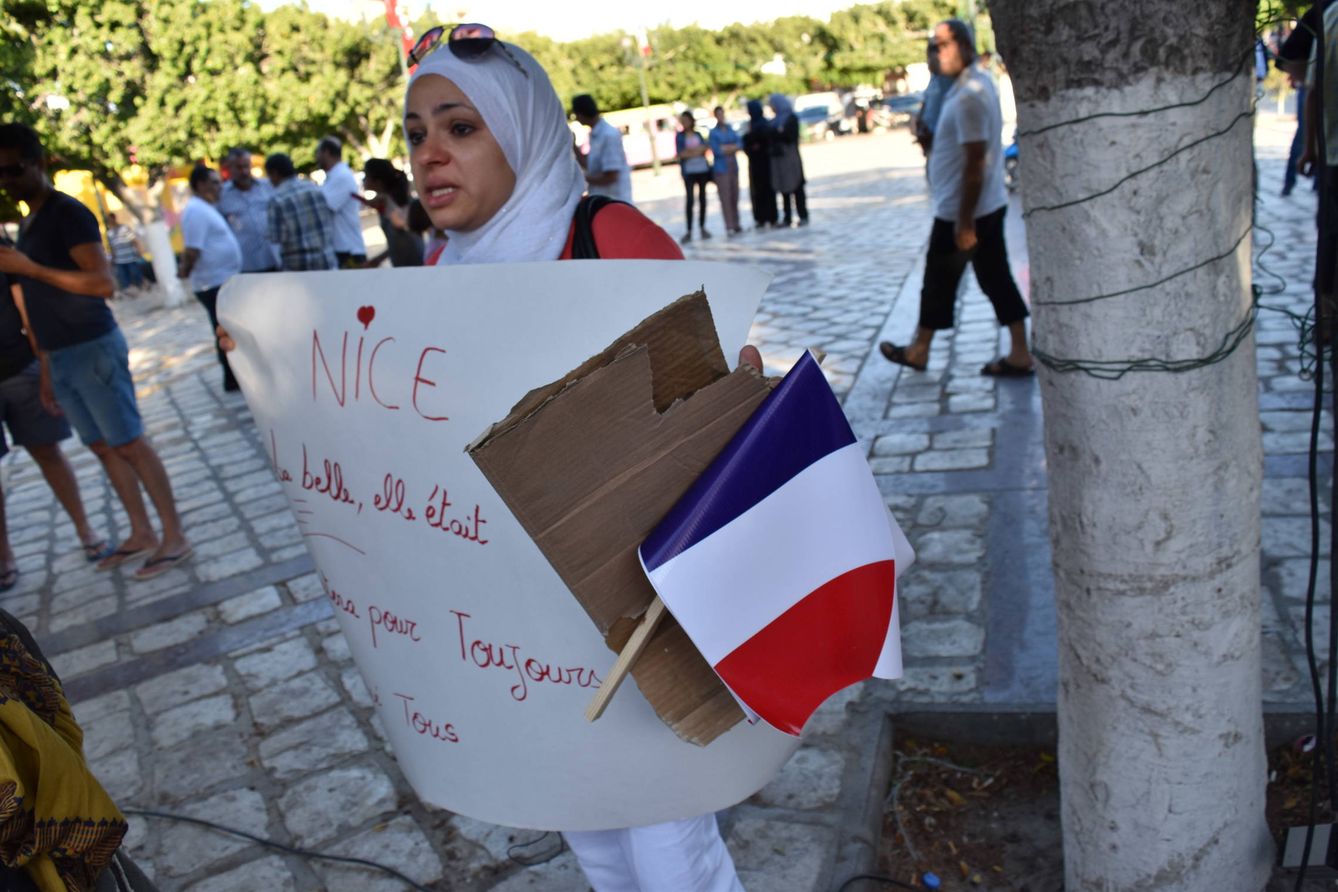 Una mujer tunecina, residente en Niza, llora mientras sostiene un cartel que reza: 'Niza, la bella, era y lo seguirá siendo siempre, pese a todo'. (L.J.V)