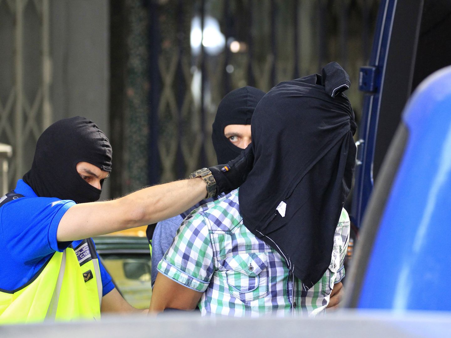 Agentes de la Policía Nacional trasladan a uno de los tres presuntos yihadistas. (EFE)