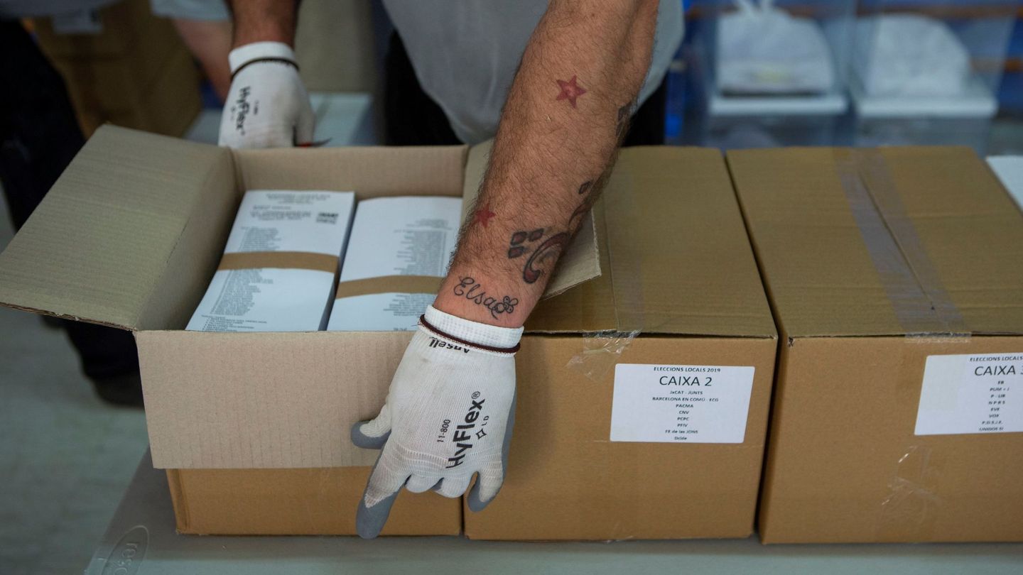 Un operario desempaqueta cajas con papeletas electorales en el almacén municipal de Barcelona. (EFE)