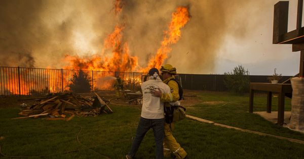 Foto: Un bombero consuela a un hombre que espera información sobre la casa de su hermana afectada por un incendio en California. (EFE)