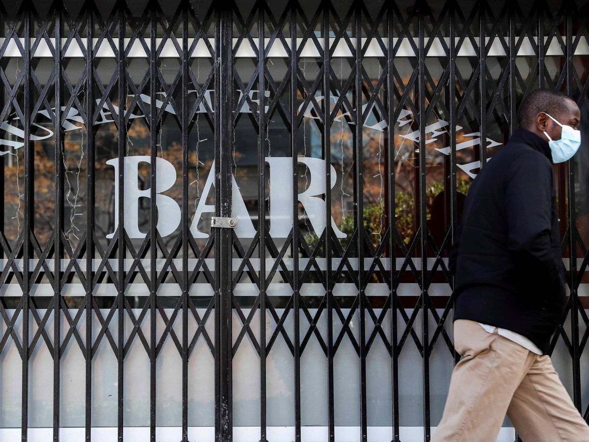 Foto: Una persona pasa por delante de un bar que permanece cerrado en Valencia. (EFE)