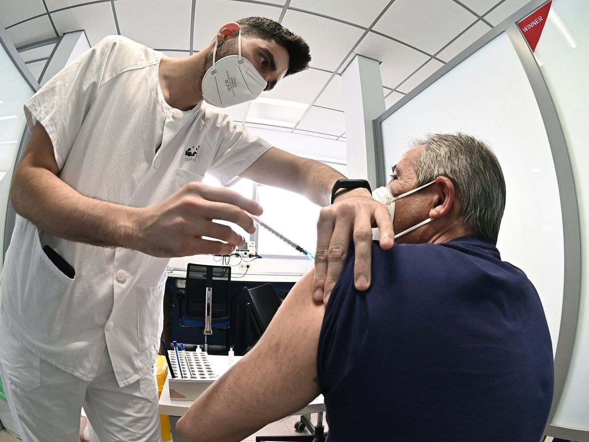 Foto: Un sanitario vacuna contra el coronavirus a un hombre en el hospital de Alcalá de Henares, en Madrid. (EFE)