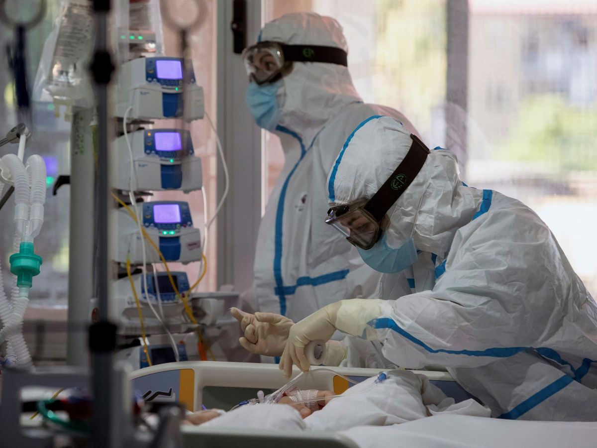 Foto: Dos enfermeras del hospital Virgen de la Arrixaca de Murcia atienden a una enferma de covid 19 en la UCI. (EFE) 